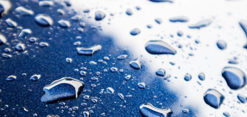 Water,drops,on,blue,powder,coated,car,surface,,focus,view.