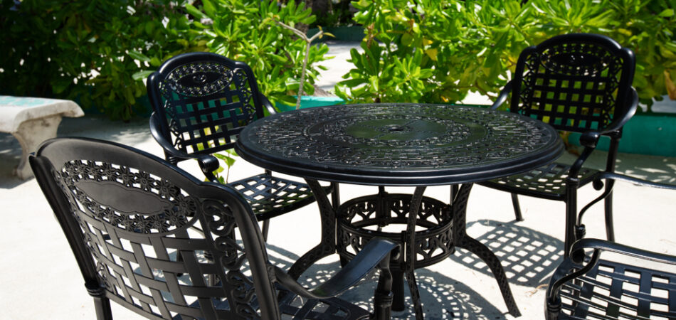 Outdoor,cafe,with,black,metal,table,and,chairs,on,tropical